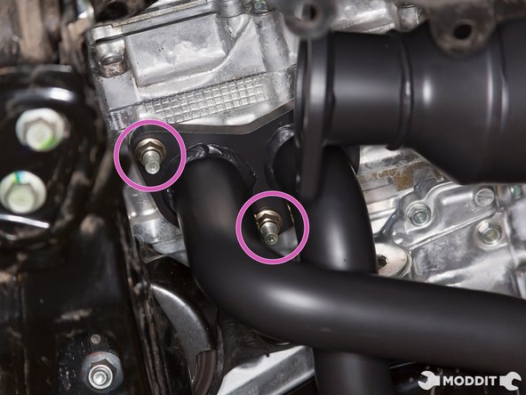 With header slipped through the studs and the gasket sandwiched between, go ahead and start threading the nuts on. These nuts can support the weight of the header so you can let go once the nuts are on the studs.