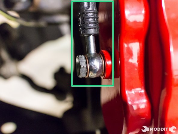 Using a 14 mm line wrench, secure banjo bolt to caliper with the stainless steel braided brake line positioning upwards.
