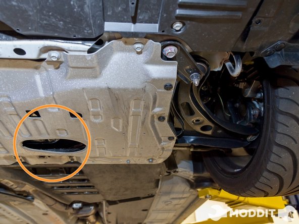 Once the car is raised position the oil capturing bucket right below where the oil escapes.