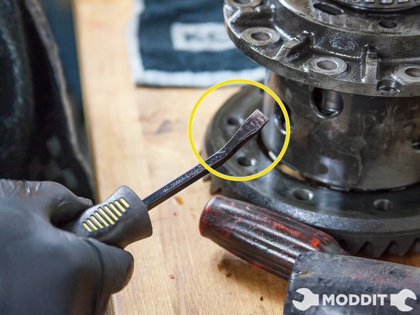 Using a combination of flat-head screwdriver, crow bar, and mallet begin taping out the ring.