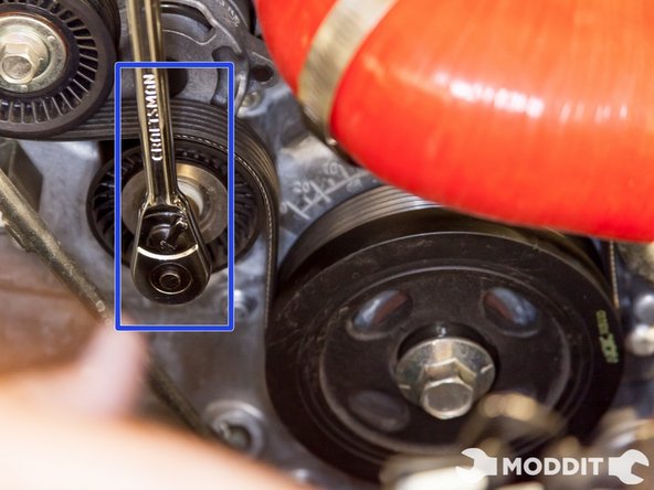 With a 14mm socket and wrench, slowly turn the tension pulley clockwise until the belt is removable.