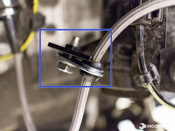 Secure but do not tighten stainless steel braided brake line to the suspension with the factory bolt.