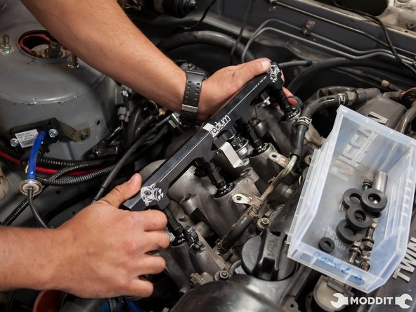 Once the injectors are lined up, evenly press the rail with the injectors into the intake manifold.