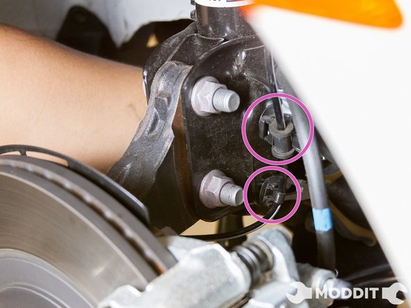 Next, remove the ABS sensor clips located on the oem strut. There are actually 2 clips to the ABS sensor line: one can use a pick, a screwdriver, or even one’s  fingers (if possible) to remove the 2 clips holding the ABS line to the strut housing.