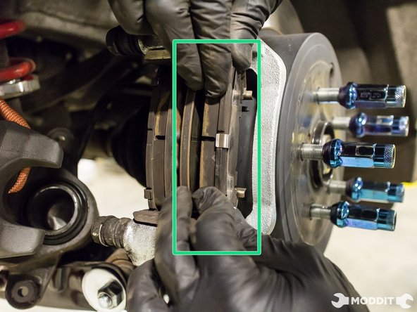 Once the caliper has been secured, the brake pads can be easily removed and set aside.