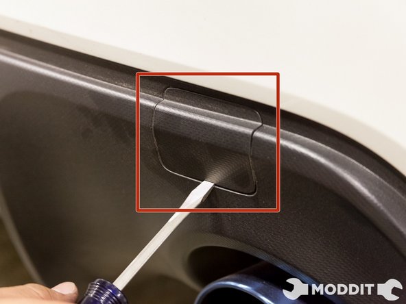 Use a flat head screw driver to remove the plastic plate covering the tow hook hole.