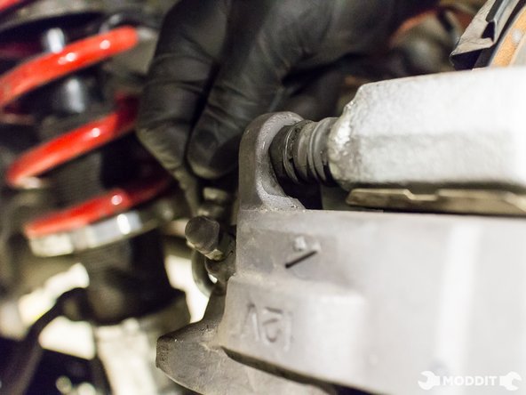 Slide the caliper on, making sure that the rubber boots do not get pinched or torn.