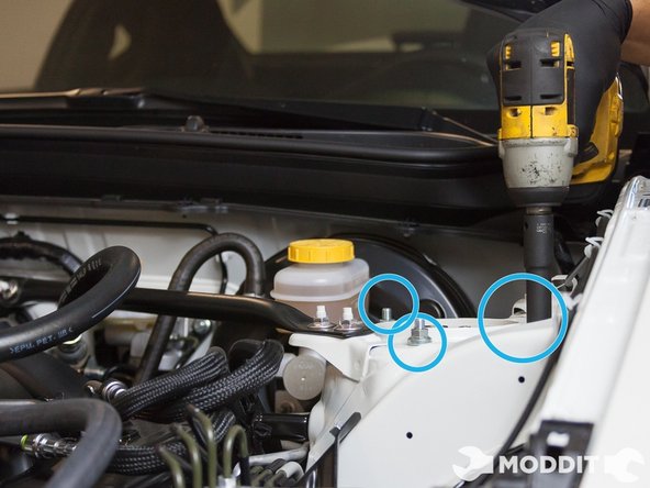 Use a 19 mm ratchet on the nut side of the strut housing to spindle bolts and a 19 mm combination wrench to secure the bolt on the opposite side. There are two of these bolts per side.