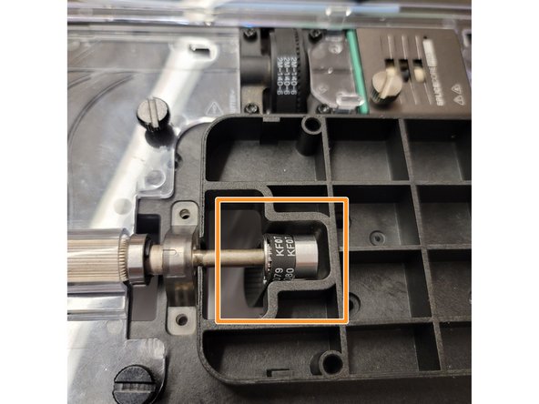 Put the drive gear shaft back in place with the belt around the sprocket.