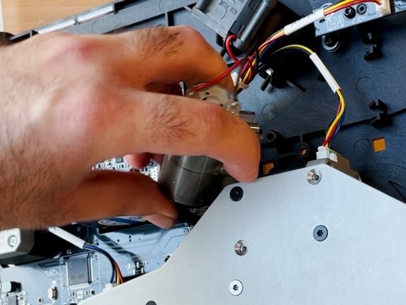 Insert the gear end of the motor into the belt, and then re-align the pins on the motor to its original position on the substructure.