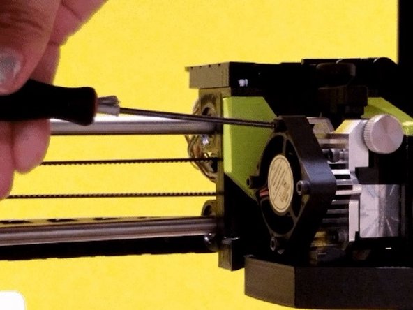 Turn off the printer. Remove 4 screws from the square fan. Gently pull the fan back and allow it to hang from the side. Place the 4 screws in a safe spot as they will be needed for reinstallation shortly.
