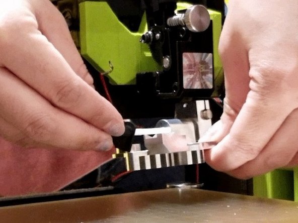 Slide this tube and guide assembly into the hot end until it is all the way into the hot end. The flat side of the guide must align with the inside of the heat sink. When the assembly is properly installed there should be no gap between the upper lip of the tube and the guide, as well as between the guide and the hot end.