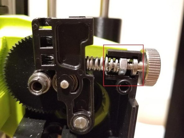 We will now begin reassembling the extruder. Put the idler spring assembly back in place. Ensure the idler spring and thumb screw is in place as shown in the photo below.