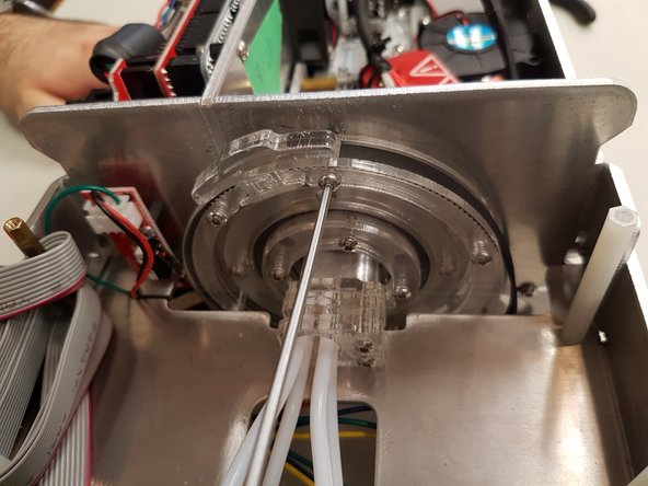 It will be easier to slide the belt in at an angle once the T-tab is lifted.  During this step, also ensure that the cutter belt is lined up with the grooves in the cutter wheel.