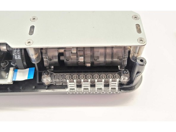 Place the new ingoing drive PCBA into place, with the cable connector towards the left. Align the holes for the screws so they can be re-inserted into place.