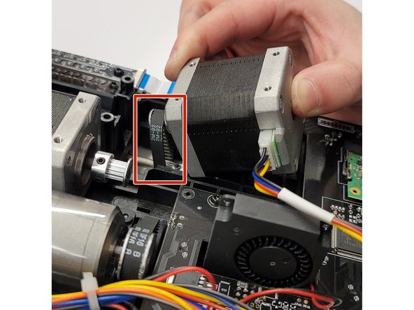 Flip the unit upside down, place motor sprocket back around the belt.