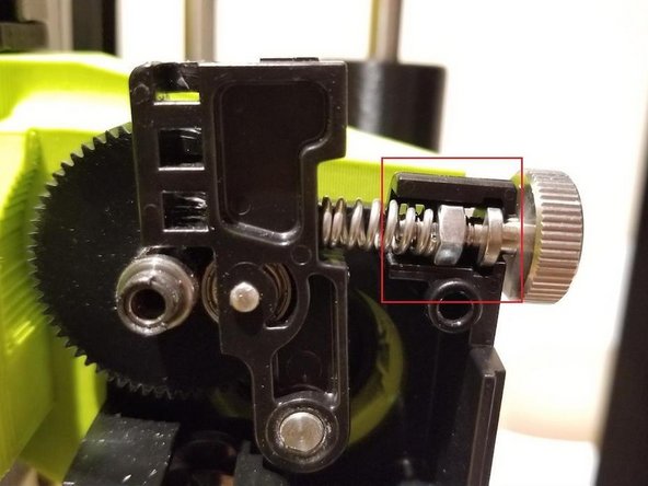 We will now begin reassembling the extruder. Put the idler spring assembly back in place. Ensure the idler spring and thumb screw is in place as shown in the photo below.