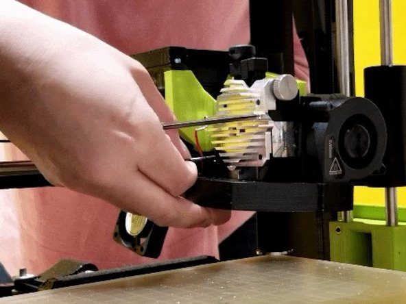 Note: Remember the placement of the shorter screw out of the four. Also, upon unscrewing the last screw on the heat sink, the cooling assembly may drop. Be cautious as the heat sink may come off by itself and the spring from the idler could pop out.