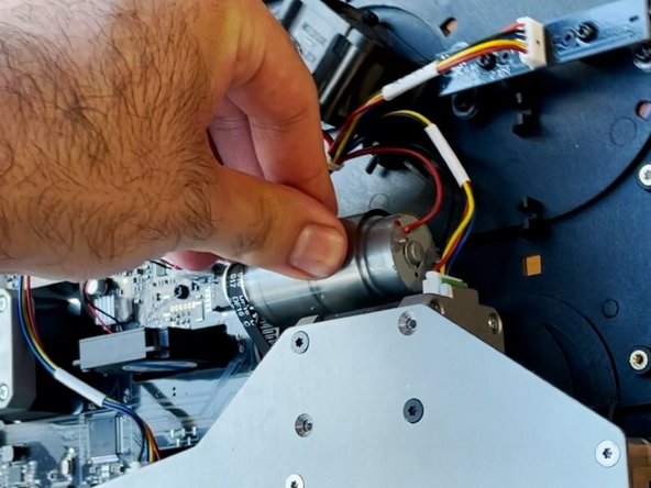 Insert the gear end of the motor into the belt, and then re-align the pins on the motor to its original position on the substructure.