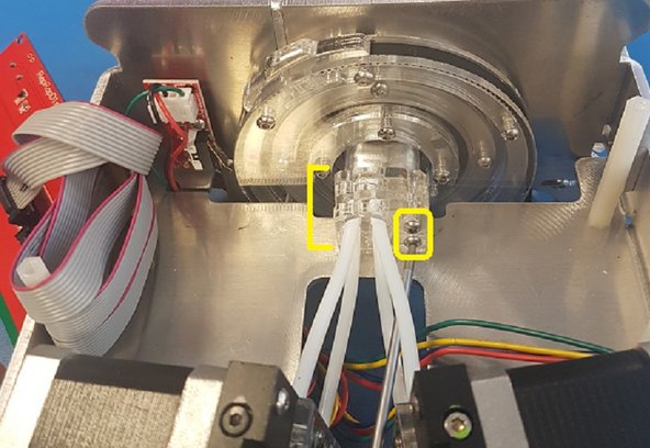 Even once the screws are removed the screen is still connected, so carefully place this piece to the side and you'll have a clear path to the merger. Carefully shift the drives to the side so that you can access the two screws which attaches the merger to the cutter. Be sure to hold the acrylic pieces together when removing these two screws.