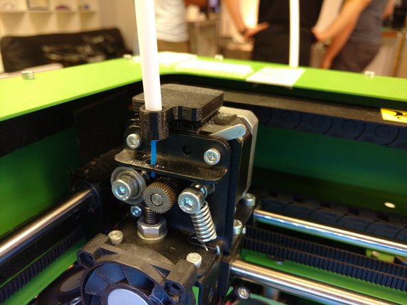 Align the Teflon tube clip (adhesive side down) with the extruder's filament path. Apply the clip to the extruder by pressing down lightly and carefully. With your Teflon tube clip secure, filament should feed easily into your extruder.