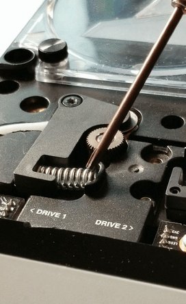 Re-screw drive arm and push spring back into place. If you push down on the drive arm and find that it bounces back slightly or has some give, please tighten the screw on the drive arm. When replacing the spring, it should be as straight as possible and rest just in the middle of its place.