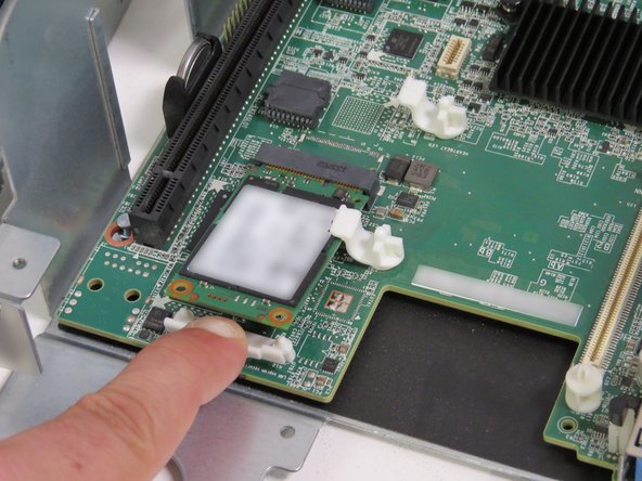 Lightly pull the drive clip towards the front of the chassis with your index finger.