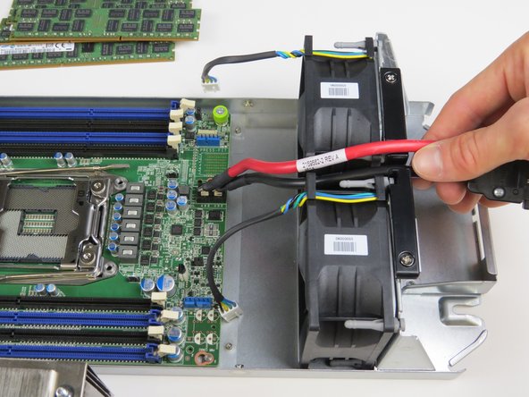 Carefully remove the motherboard power cable from in between the (2) fans as shown.