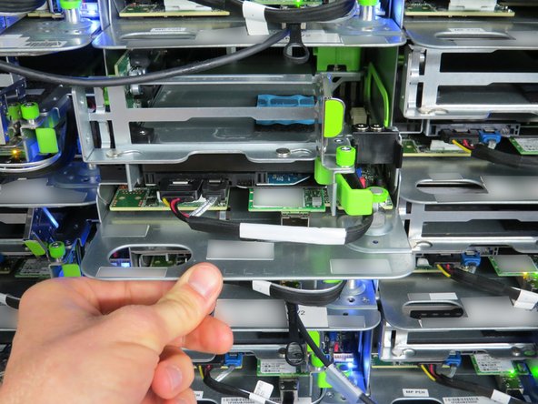 If the green retention plunger is still in the upright position, twist it 90 degrees to release it. This will secure the server.