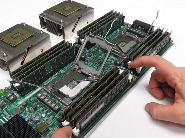 Press downwards on the DIMM retention tabs.