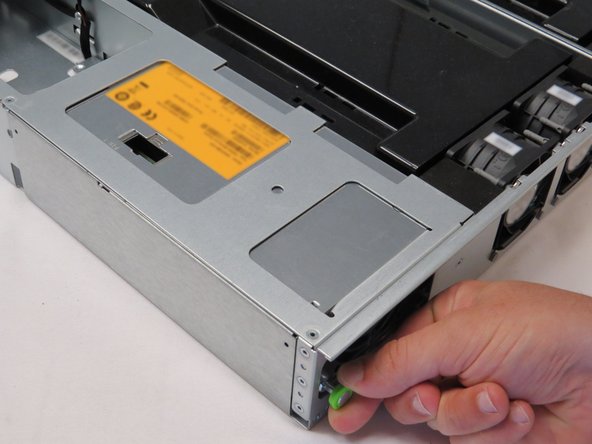 Push the PSU away from the chassis while holding the plunger outwards, as shown.