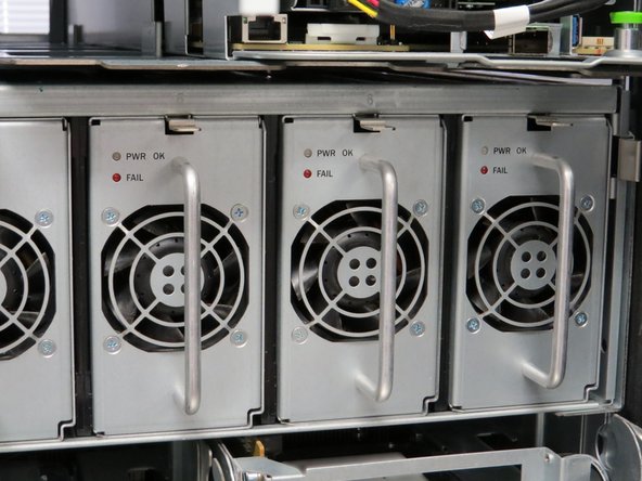 Locate the retention tab at the top of the power module unit.