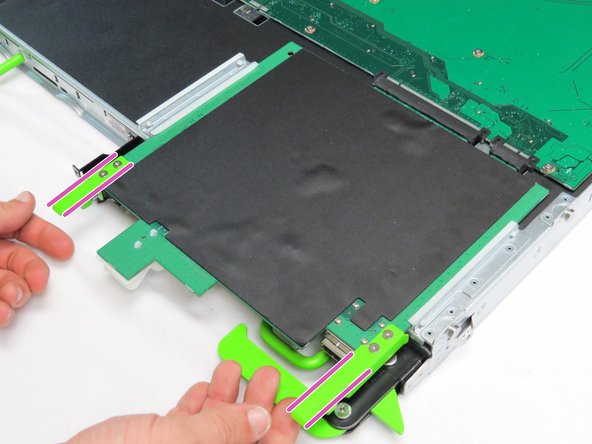 Pull the two tabs located on the front end of the expander board, as shown.