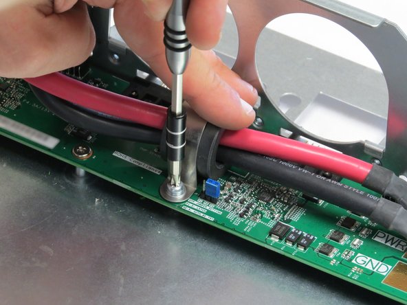 Screw in the Phillips #2 screw to secure the bus lead management clip to the fan controller board.