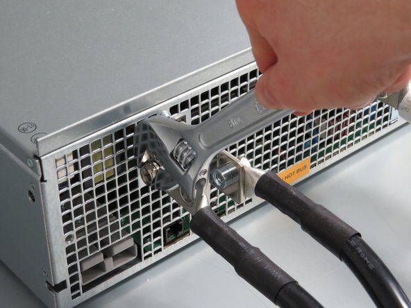 Using a wrench of Phillips screwdriver, remove the bolts attaching the lug cables to the power shelf rails.