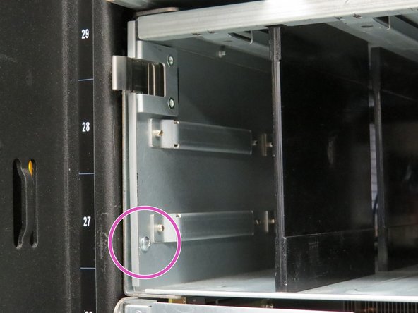 Remove the Phillips #2 screw located on each side of the power shelf.