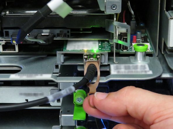 Disconnect the 10G SFP+ cable by pulling on the pull-tab, as shown.