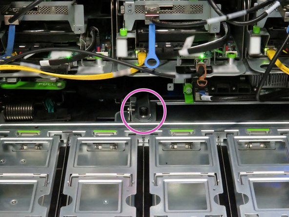 Locate the black thumbscrew in the middle-rear of the storage tray.