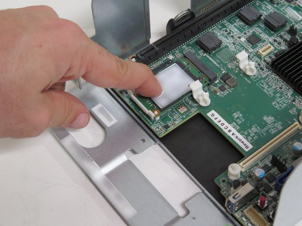 Press down on the mSATA drive until the white nylon retention clip secures the mSATA drive.