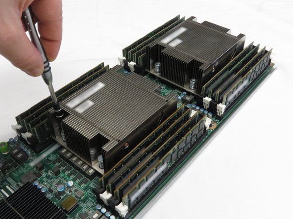 Using a cross-torque technique, loosen the Phillips #2 screws in a diagonal pattern to disconnect the CPU heatsinks from the motherboard.