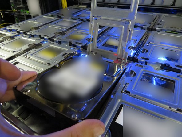 Lightly place the new HDD into the vacant tray slot.