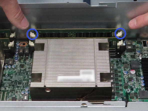 Push the (2) DIMM retention tabs.