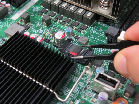 Use tweezers (or a similar tool) to extract the BIOS chip from the motherboard.