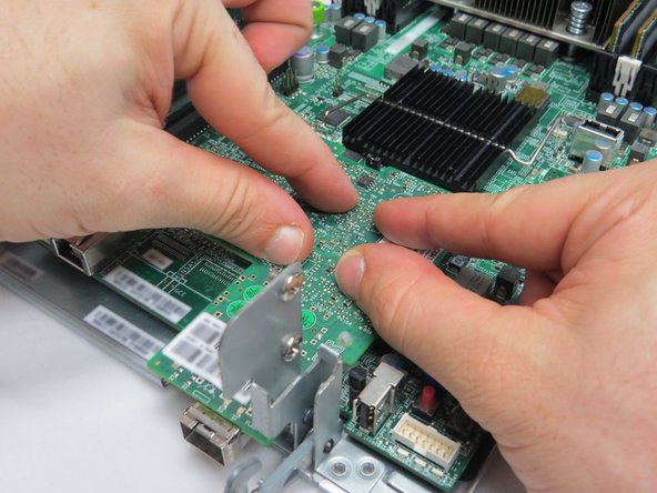 Ensure that the four nylon risers have locked the NIC to the motherboard.