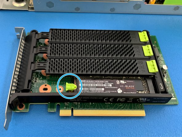 Pull back green tab, gently push the SSD down and release the green tab  to lock the SSD in place.