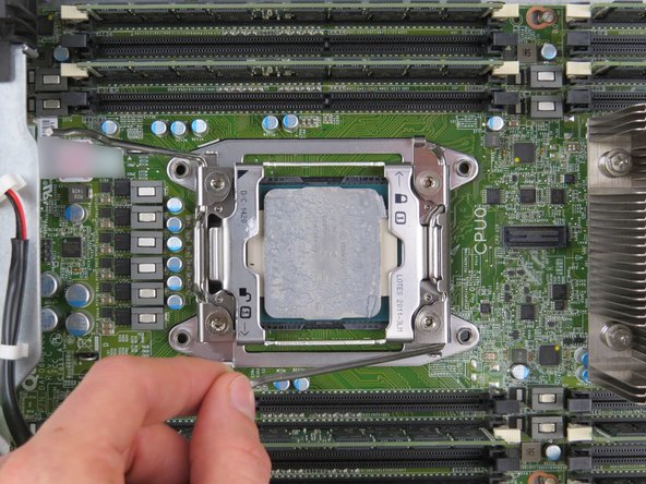 Press the first 'unlock' retention lever down towards the CPU to allow the CPU retention bracket to lift.