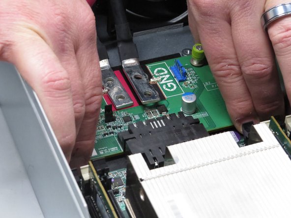 Slide the board towards the back of the server.