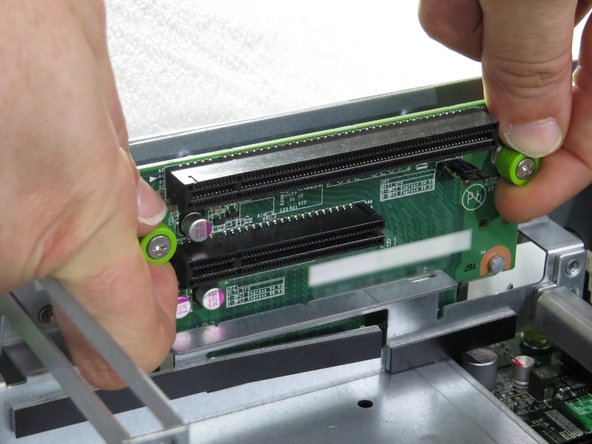 Loosen the two thumbscrews securing the riser card to the riser cage.