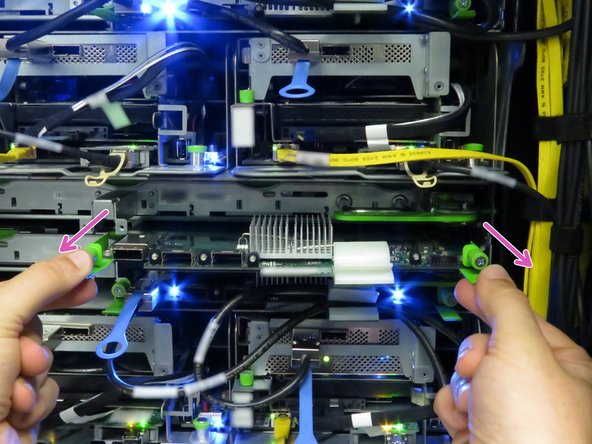 Pull on the two tabs to remove the SAS expander board from the storage tray, as shown.