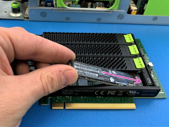 Pull back green tab, gently push the SSD down and release the green tab  to lock the SSD in place.